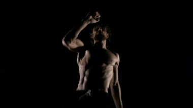 Kaslı sporcu karanlık arka planda karate pratik