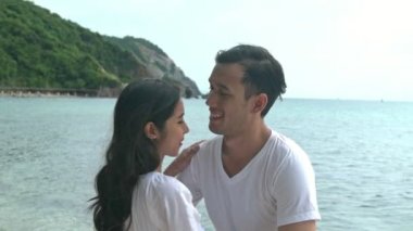 Çekici genç çift romantik sahilde. Tutkulu öpücük güneş sırasında birlikte ayarlayın. Erken 20s beyaz adamla Genç Çinli kadın. Karışık yarış. Ağır çekimde vurdu. Film bak.