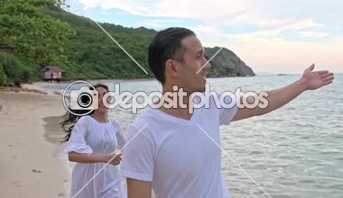 Çekici genç çift sahilde eğleniyor. Çalışan ve piggy geri döndü. Erken 20s beyaz adamla Genç Çinli kadın.