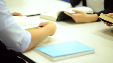 Sınıfta kitap okuyan bir grup öğrencinin yakın çekimi.