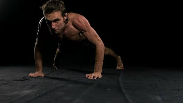 男人在做黑色背景的俯卧撑 半裸男 慢动作 — 图库视频影像