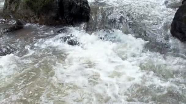 Rivière de montagne fraîche et propre qui coule entre les rochers au ralenti. Pris en plein air par temps nuageux .