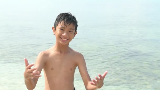 タイのビーチで幸せな子 カメラにポーズに来る タイ旅行 休日休憩の昇進 スローモーションで撮影します — ストック動画