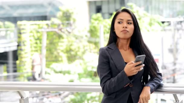 モバイル オフィスのコンセプトです 若いビジネス アジア女性が彼女のオフィスの外彼女の休憩の間にプライベートの電話での会話を持っていること コントロールの下のものを取得しようとしました ミディアム ショット — ストック動画