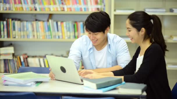 Mladí studenti se pilně studovat v knihovně. Happy asijské ženské a mužské vysokoškolských studentů dělá studie výzkum v knihovně knihy na stole, poznámkového bloku. Pro zpátky do školy rozmanitost koncepce. 