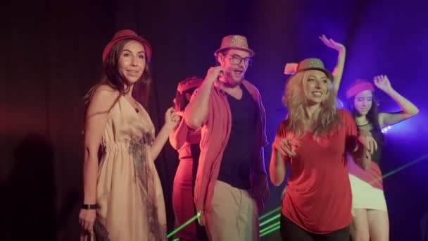 ダンスをしたり 夜のクラブのダンスフロア上の友人とパーティの音楽を応援して多くの女性とハンサムな男の多民族のグループ スローモーション中 — ストック動画