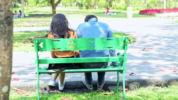 年轻夫妇在公园里一起玩 亚洲夫妇坐在板凳上 互相拥抱 爱情和关系概念 — 图库视频影像
