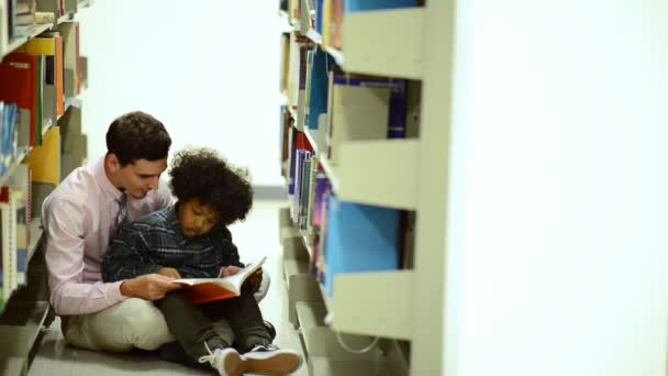 Lehrer Und Schüler Lesen Bücher Auf Dem Boden Der Bibliothek — Stockvideo