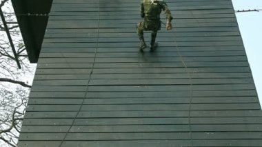 Asker halatla eğitim duvarından aşağı iniyor. 