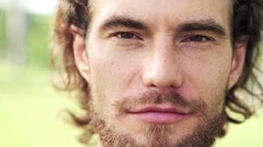 Genç adam portresi. Sakal gülümseme önde kamera doğa manzarasıyla arka planda ile beyaz erkek.