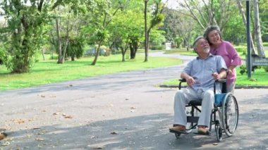 Parkta yaşlı bir çift. Parkta Çinli eski çift, rahatlatıcı, gülümseyen ve birbirleriyle konuşmak.