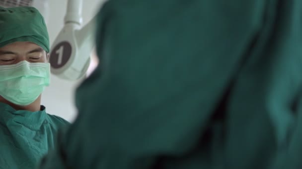 Хирург Работе Молодой Кавказский Хирург Своей Мультиэтичной Командой Проводит Операцию — стоковое видео