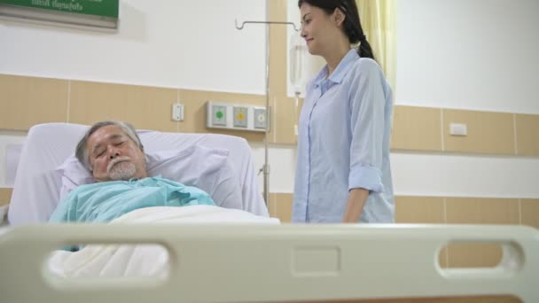 护理者把老年病人送到医院睡觉 年轻漂亮的女性护理者给她的高级男性病人毯子 在他睡觉时安慰他 高级服务理念 Zoomin — 图库视频影像