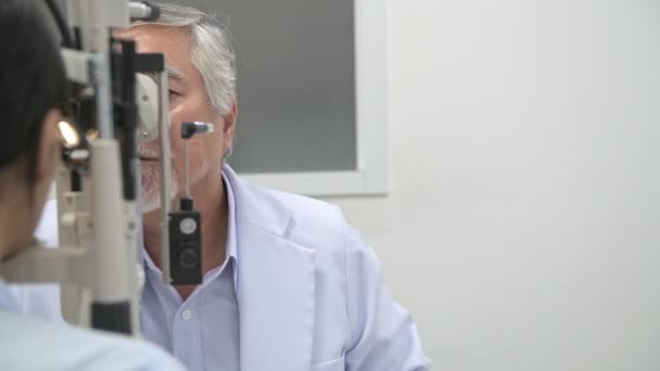 仕事で眼鏡 シニアの中国眼鏡肖像画目視力測定機械の運転 病院のリアル眼鏡室 医療コンセプト — ストック動画