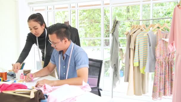 时装设计师在工作 年轻的中国男女时装设计师和裁缝绘图设计概念在笔记簿在他们的家办公室 小企业创业理念 — 图库视频影像