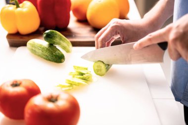 Kadın mutfakta salatalık doğrama.