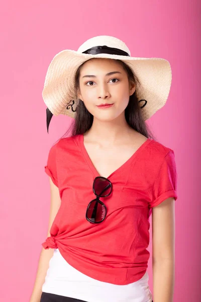 夏の服装と帽子立っているとピンク背景に分離カメラを見てポーズで笑顔の魅力的な女性の肖像画 — ストック写真