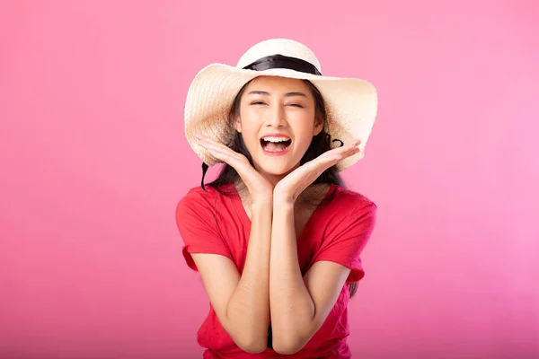 Portrait of a wow suprise smile attractive woman in summer outfit and hat posing while standing and looking at camera isolated over pink background.
