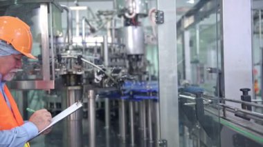 Kalite kontrol fabrikasında. Tky, Tpm metodoloji kullanarak fabrikası bir sıvı dolum şişesi makine teftiş üst düzey Çinli kalite güvence ekibi. Mükemmellik üretim kavramı.
