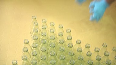 Fabrika işçisi malzeme çekme şişe dolum Makinası için. Temiz eldiven ile. Üretim kavramı.