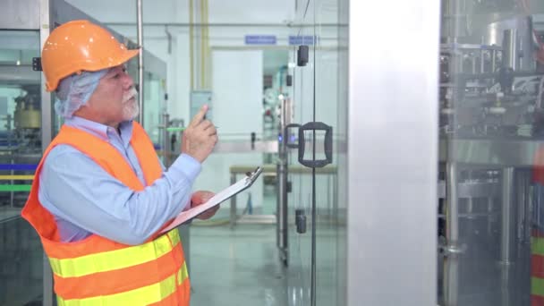 Mâle Asiatique Senior Qualité Inspecteur Dans Usine Écriture Notes Sur — Video