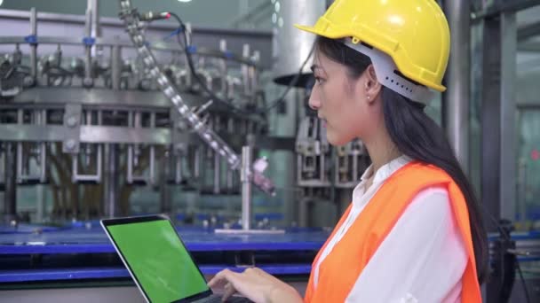 女工业工程师在工厂工作 一位年轻漂亮的中国工程师在大工厂工作 戴安全帽和夹克 自动化背景的高科技自动机 — 图库视频影像