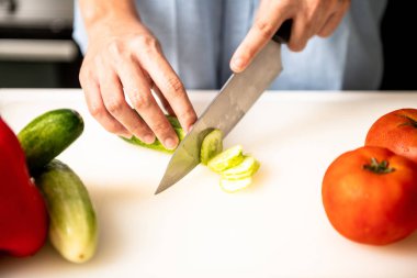 Kadın mutfakta salatalık doğrama.