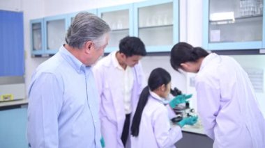 Laboratuvar portresini bir bilim adamı. Laboratuvar portre takımı arka planda çalışan üst düzey Çinli erkek bilim adamı.