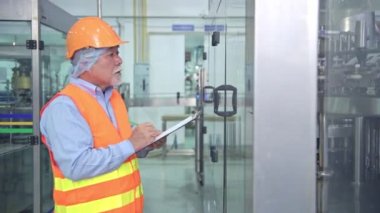 Kalite kontrol fabrikasında. Tky, Tpm metodoloji kullanarak fabrikası bir sıvı dolum şişesi makine teftiş üst düzey Çinli kalite güvence ekibi. Mükemmellik üretim kavramı.