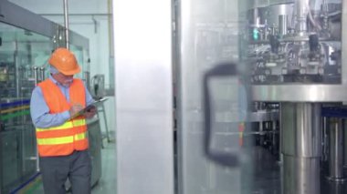 Kalite kontrol fabrikasında. Tky, Tpm metodoloji kullanarak fabrikası bir sıvı dolum şişesi makine teftiş üst düzey Çinli kalite güvence ekibi. Mükemmellik üretim kavramı.