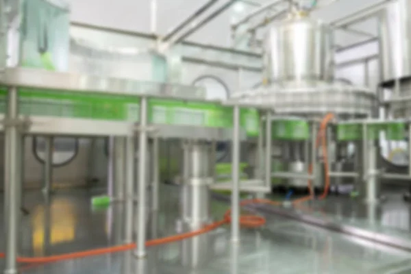 Blur background of Beverage production line. A conveyor belt full of empty plastic bottle going into bottle filling machine. Beverage manufacturing concept.