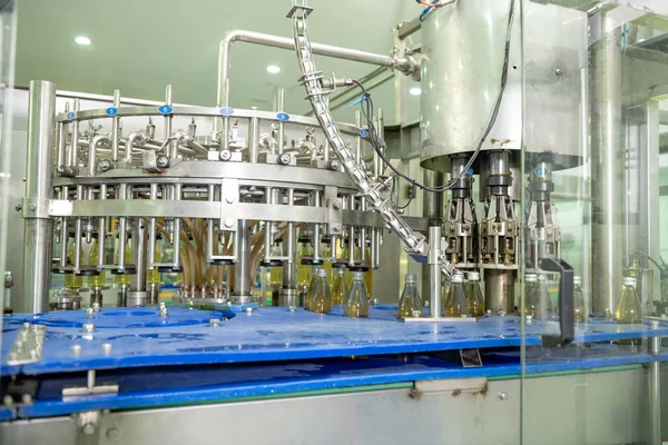 Beverage production line background. A liquid bottle filling machine with bottle inside operating. Beverage manufacturing concept.