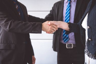 İşadamı birlikte el salla. Üst düzey beyaz adamla birlikte el sallayarak elbiseli Genç Asyalı işkadını.