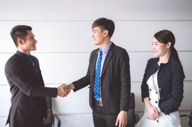 İşadamı birlikte el salla. Onun çalışan ile el sallayarak kadınla elbiseli Genç Asyalı işadamı.