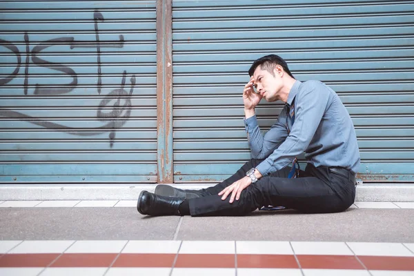 無職の男が路上で座っています アジア男はストレスを探して 閉鎖店の背景を持つ感情的な — ストック写真