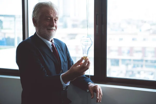 Senior Business Man Håller Glödlampa Vit Hane Kostym Ser Glad — Stockfoto