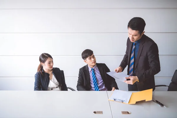 Businessman ripping off contract document. Young asian male in suit with beautiful young asia woman sitting together and saw man ripping off their contract document. Employment termination concept.