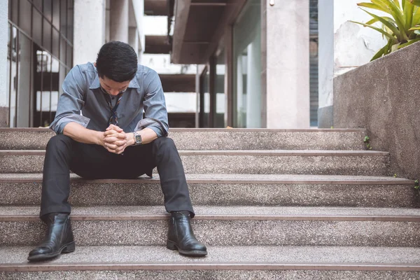 無職の男が路上で座っています アジア男はストレスを探して オフィスビルの背景と感情的な — ストック写真