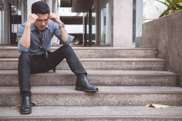 無職の男が路上で座っています アジア男はストレスを探して オフィスビルの背景と感情的な — ストック写真