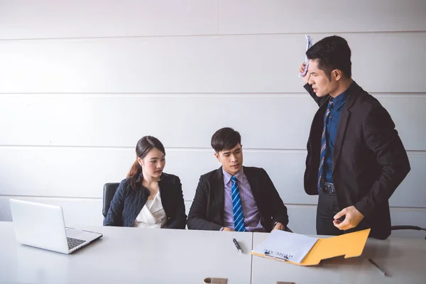 Businessman ripping off contract document. Young asian male in suit with beautiful young asia woman sitting together and saw man ripping off their contract document. Employment termination concept.