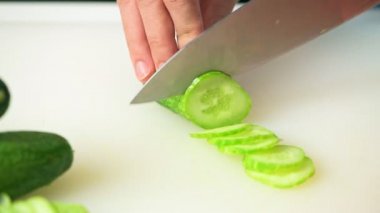 kadın tencere salatalık Doğrama Kurulu üzerinde bıçak ile dilimleme