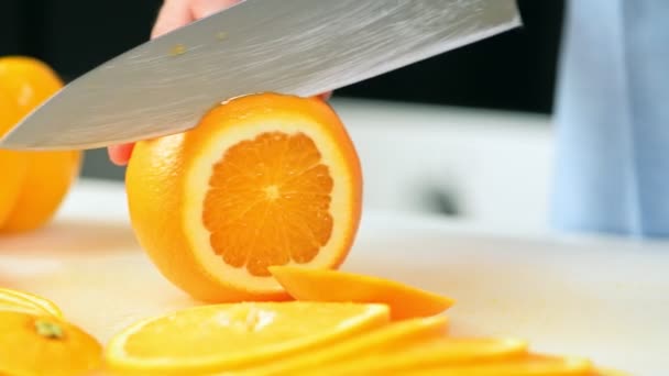 Frau Schneidet Orange Mit Messer Auf Schneidebrett — Stockvideo