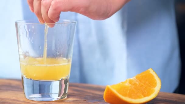 Mujer Exprimiendo Jugo Naranja Vaso Mesa — Vídeos de Stock