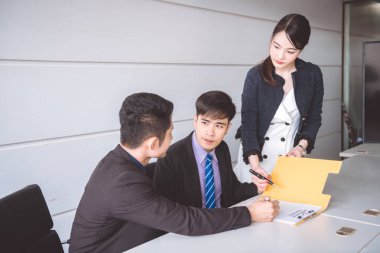 İşadamı imza sözleşme belge. Genç Asyalı erkek ile birlikte oturan ve sözleşme Belge imzalama güzel genç Asya kadın elbiseli. Başarılı iş anlaşma kavramı.