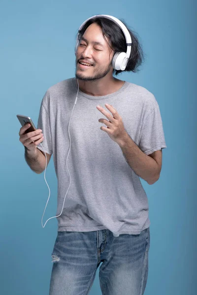 Ung Skäggig Man Lyssnar Musik Blå Bakgrund Glad Asiatiska Unga — Stockfoto