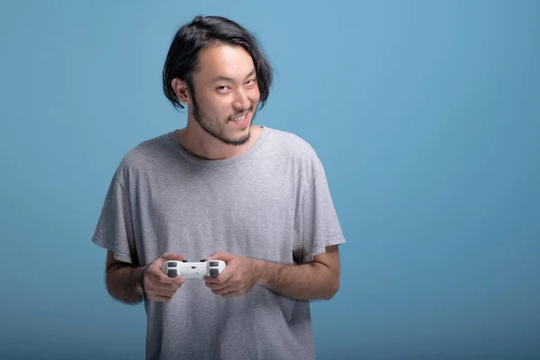 Ung Skäggig Man Spelar Videospel Blå Bakgrund Mycket Glad Asiatiska — Stockfoto