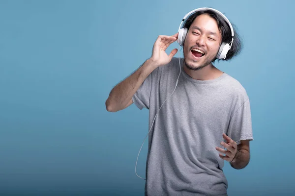 Young Bearded Man Listening Music Blue Background Extremely Happy Asian — Stock Photo, Image