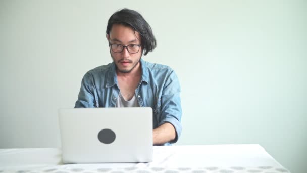 Asiatischer Junger Mann Mit Brille Benutzt Laptop Und Wird Angenehm — Stockvideo