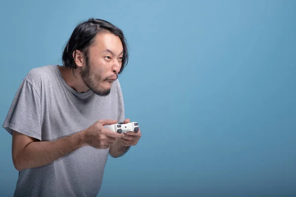 Mladý Vousatý Muž Hraje Videohry Modrém Pozadí Velmi Aktivní Asijské — Stock fotografie