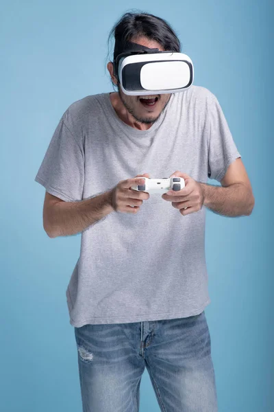 Молодой Бородатый Человек Играет Виртуальную Игру Синем Фоне Взволнованный Азиатский — стоковое фото